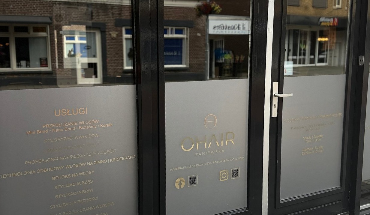 De etalage en deur van OHAIR aan de Zandstraat, met het logo op het glas